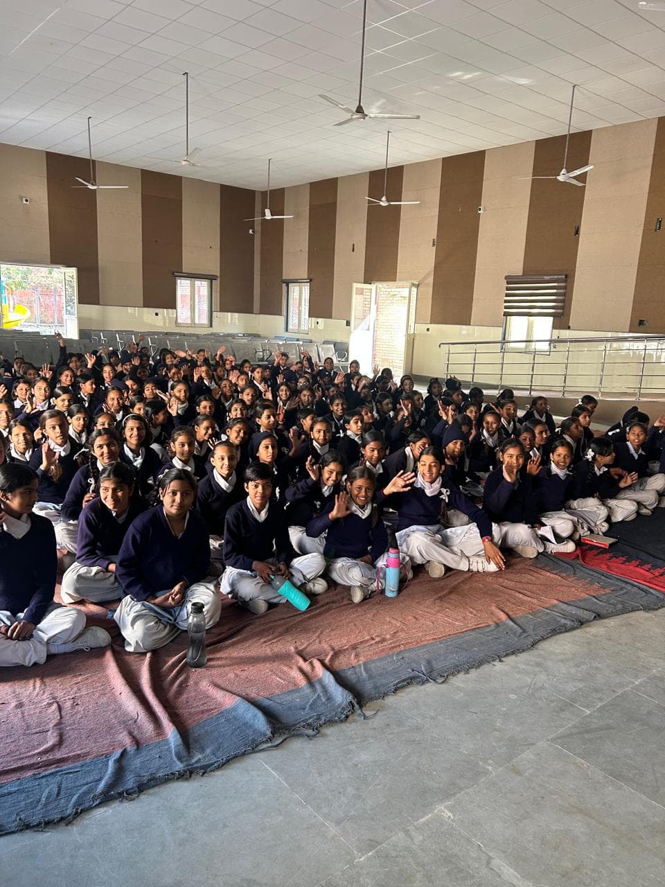 A large group of schoolgirls waving during a session