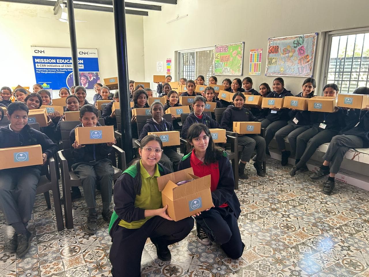 EmpowerHer volunteers with an open FlowKit and students