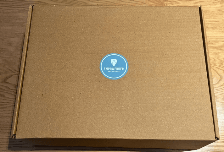 A sealed EmpowerHer FlowLab Kit box with the branded label